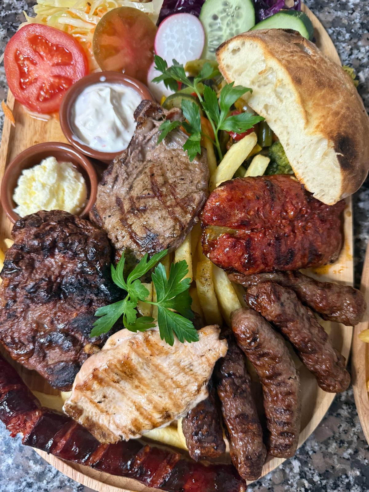 Gemischte Grillplatte mit verschiedenen Fleischsorten, Brot und frischen Beilagen